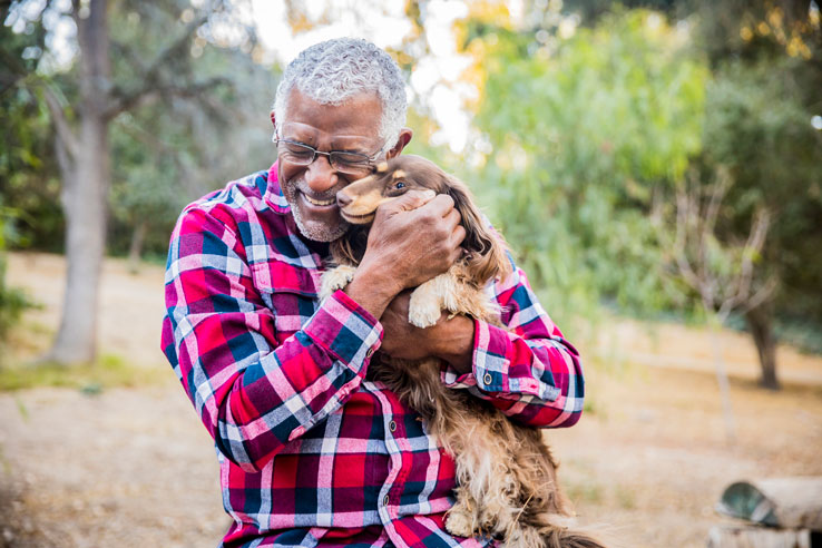 older man holding a puppy - stress in seniors