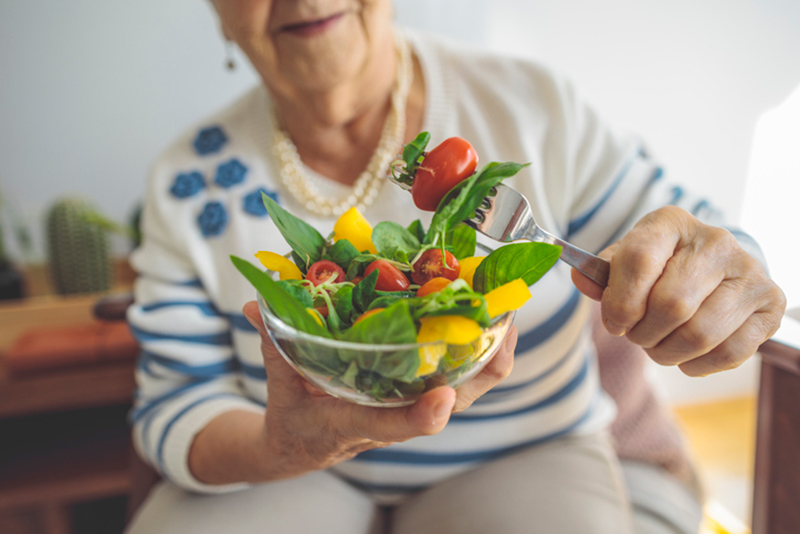 senior lady holding heart healthy salad
