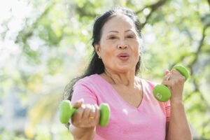 A woman includes hand weights as part of her exercise routine that is aimed at preventing and recovering from strokes.