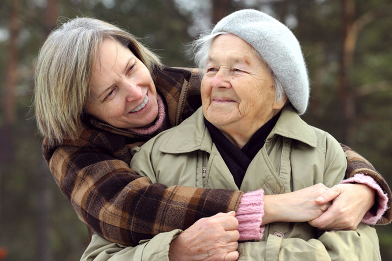 A woman hugs her aging mother. She is one of millions of family caregivers across the US who could benefit from respite care services.